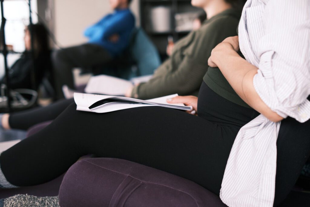 pregnant woman holding her belly in prenatal birth class
