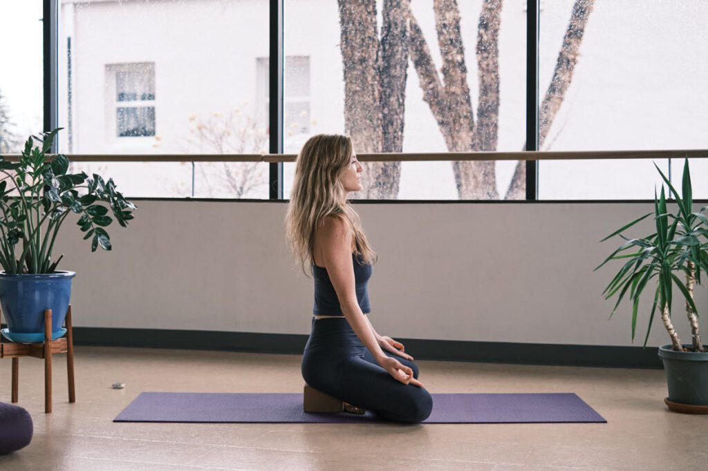 yoga teacher in a studio demonstrating good postural alignment
