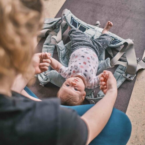 mom holding her baby's hands in barre class