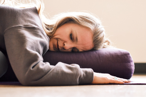 A person resting on a bolster.