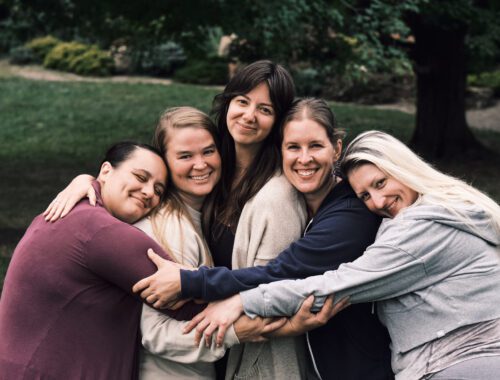 team of minneapolis doula women standing and hugging outside