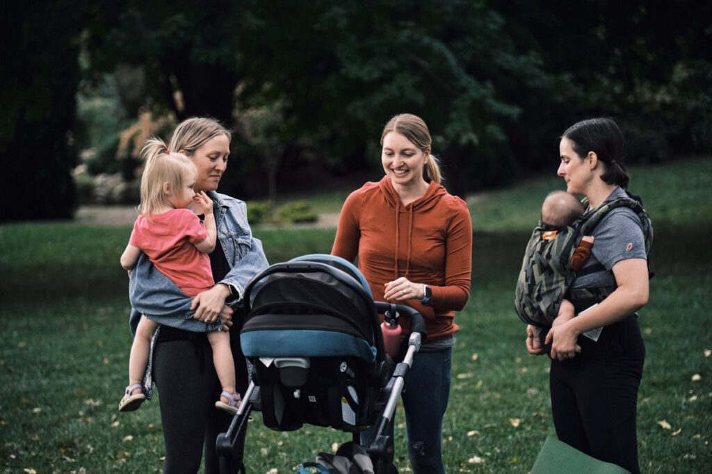 three women with babies standing and talking after yoga