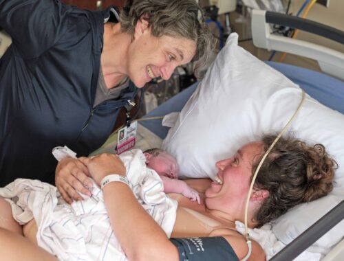 midwife and new mom smiling at each other after birth